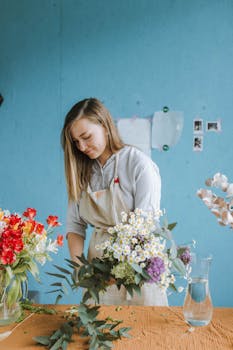 一位女花艺师在车间桌子上布置了一束美丽的鲜花