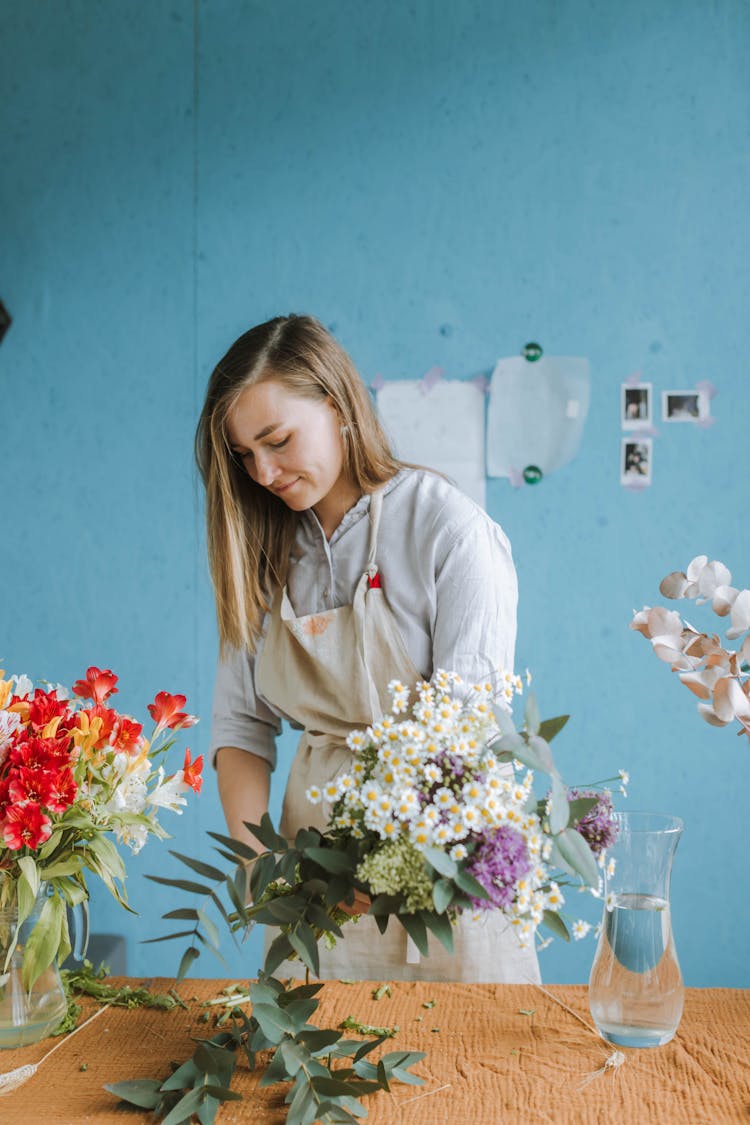 Woman Cutting Stems Of Flowers