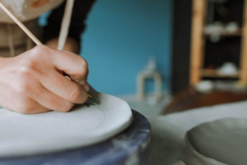 Person Painting on Clay Plate