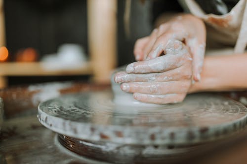 Free Hands Making Clay Pot on Brown Wooden Table Stock Photo