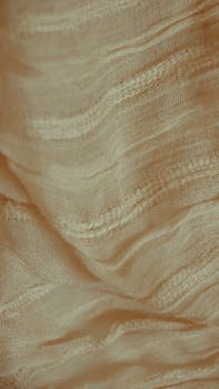Detailed close-up of beige fabric showing intricate woven texture and patterns.