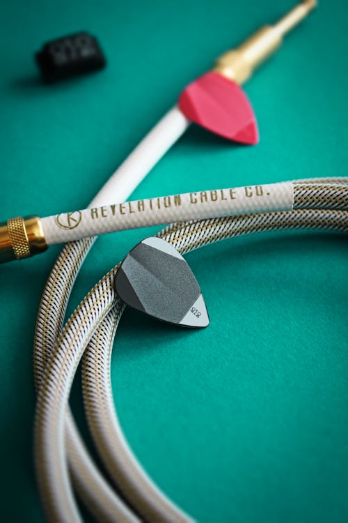 Plectrums and White Cable on Green Surface