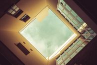 Worms Eye View of Brown Concrete Building Under Blue and White Sunny Cloudy Sky