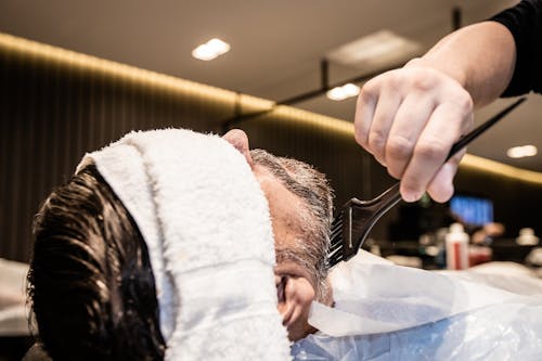 A Man Getting a Grooming Service in a Barber Shop