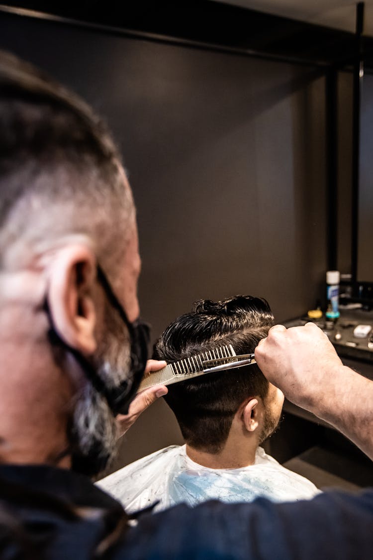 A Barber Cutting The Hair Of The Client