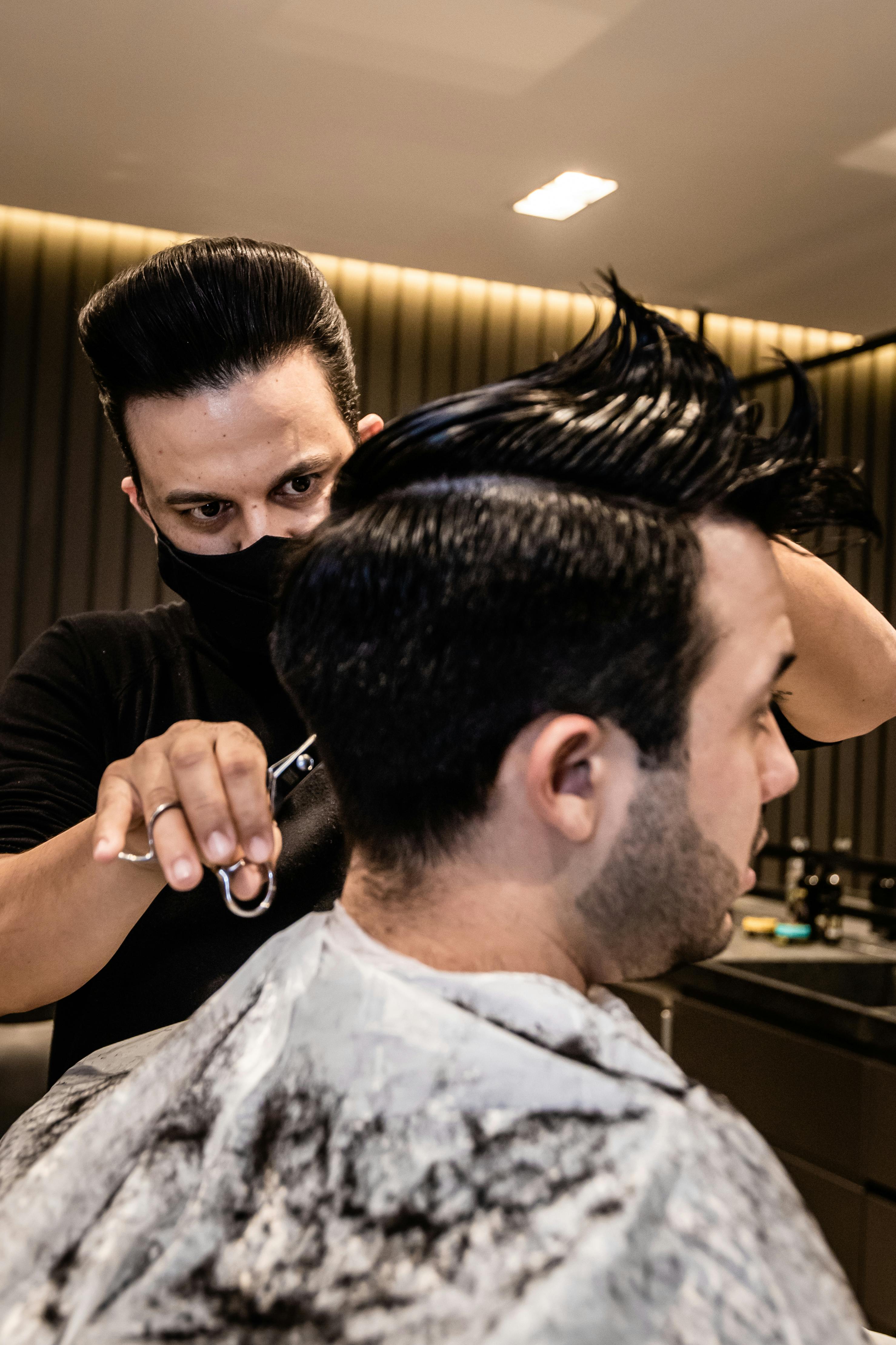 a barber cutting the hair of the client