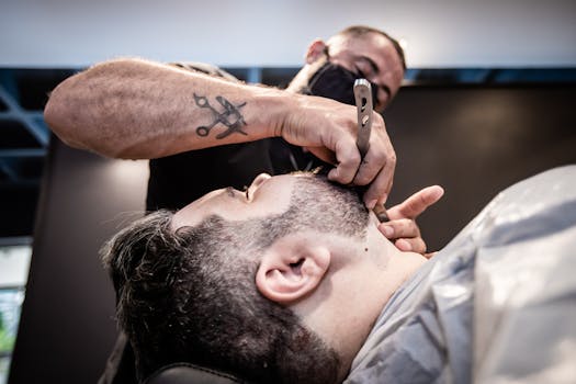 Close-up shot of a barber skillfully trimming a client's beard inside a barbershop.