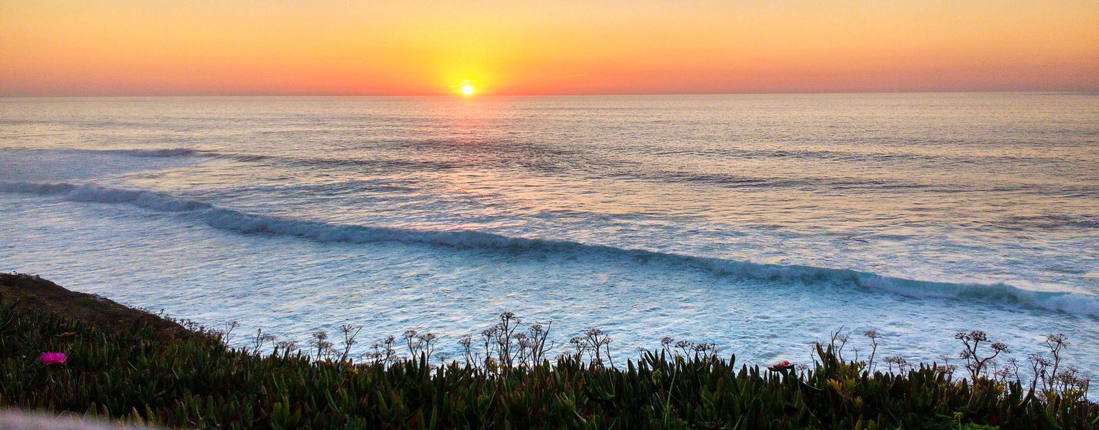 Beautiful sunset over Ericeira's coastline, capturing the calm Atlantic waves and vibrant evening sky.