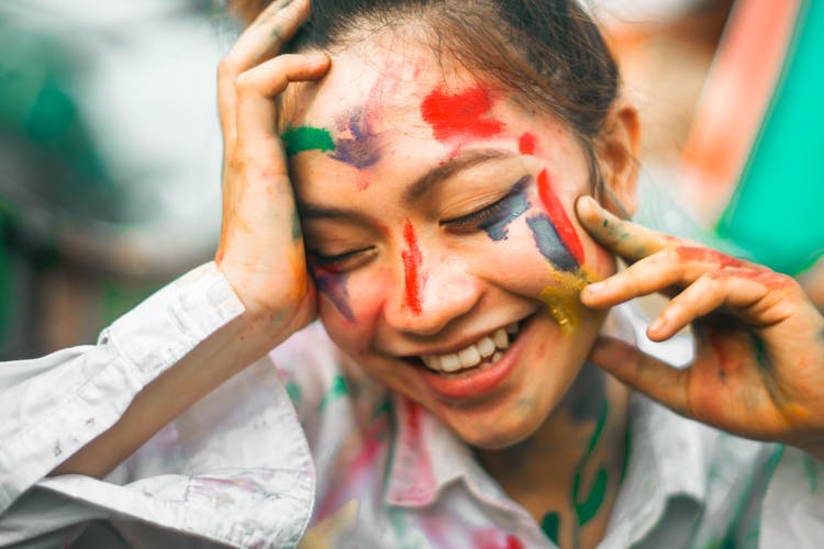 Positive Woman With Spots Of Paint On Face