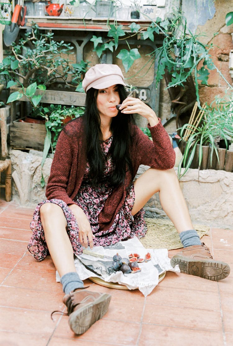 Woman Sitting On The Floor Eating Fruits