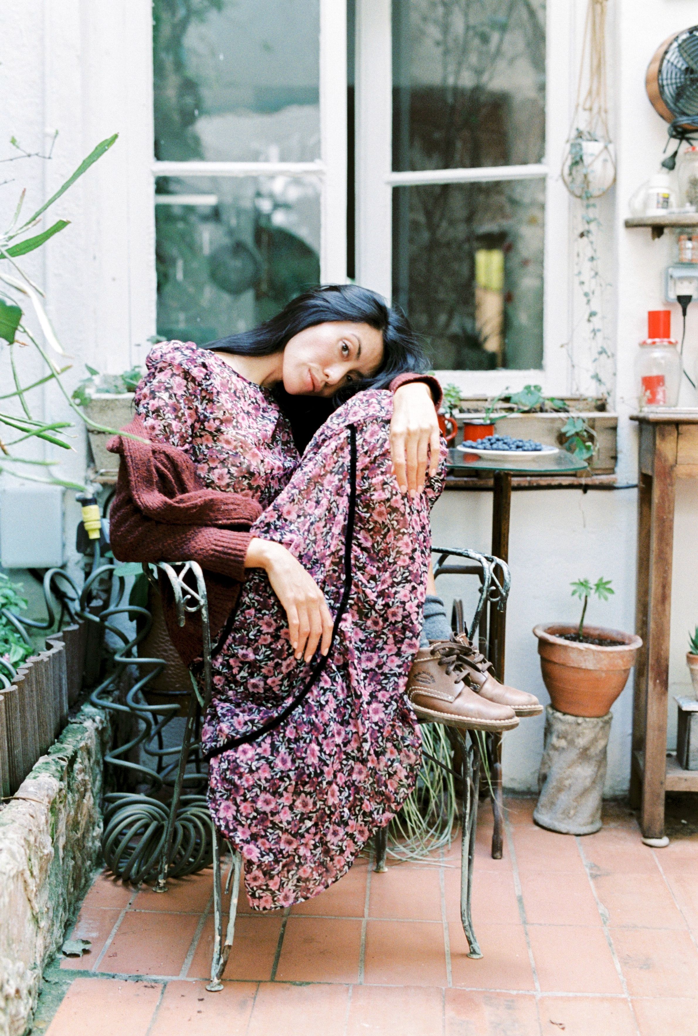 A Woman Wearing a Flora Dress Sitting on a Chair · Free Stock Photo