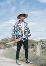 Photo of a Boy with an Asian Conical Hat Holding a Sword