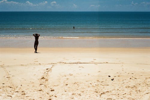 Photo of a Person Walking on Sand During the Day