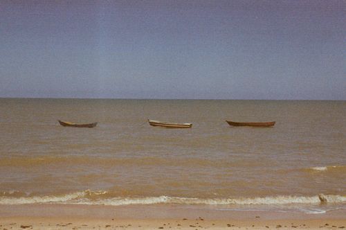 Free Vintage photo of three boats adrift on a quiet Brazilian seashore, creating a serene and nostalgic scene. Stock Photo