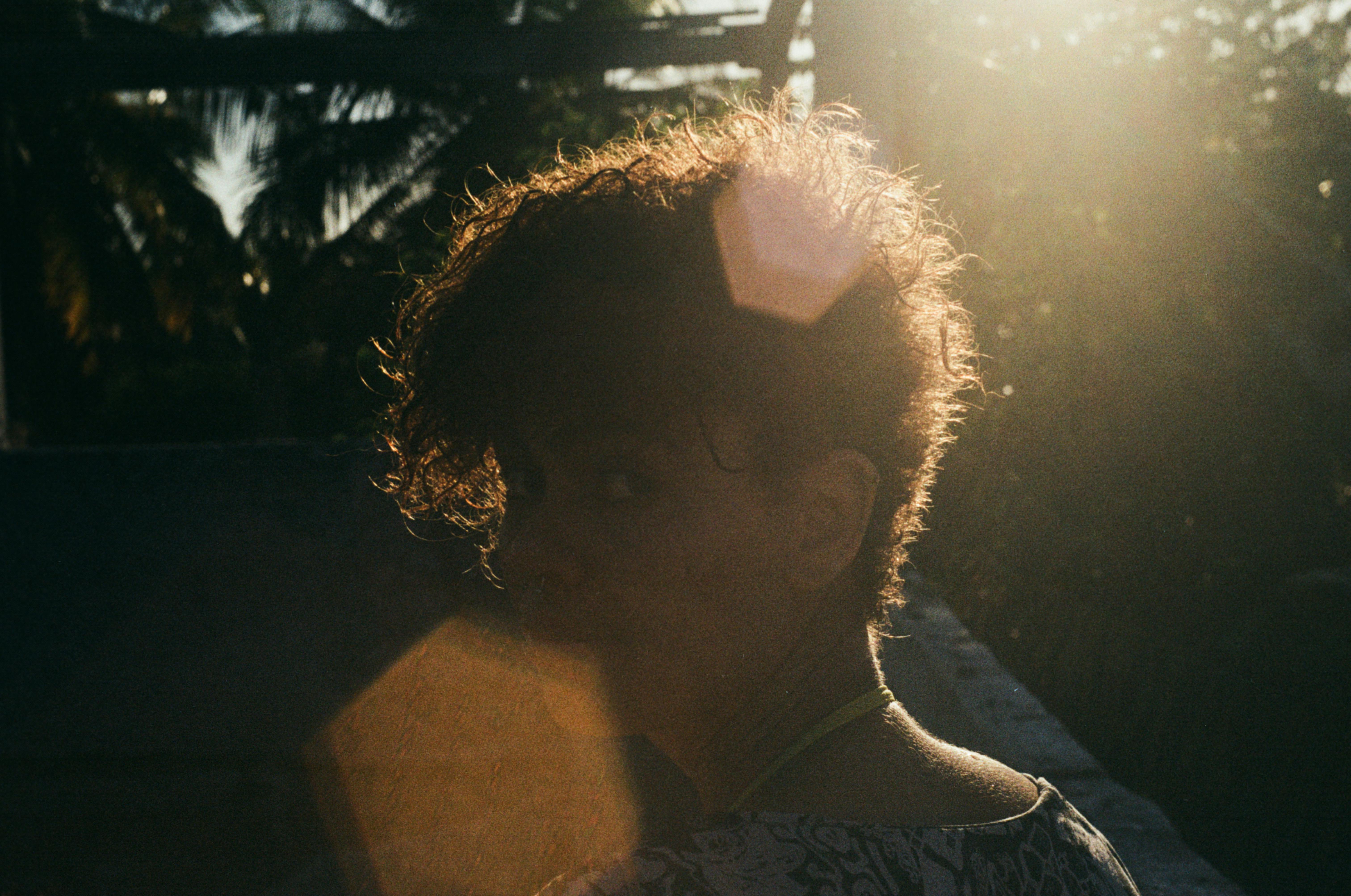 Mulher em momento introspectivo, com expressão contemplativa e luz natural