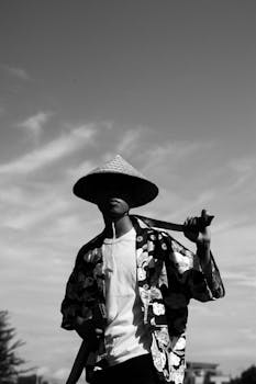 戴着传统亚洲锥形帽、佩剑者的黑白轮廓