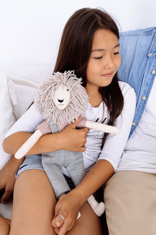 Photograph of a Girl Hugging a Stuffed Toy