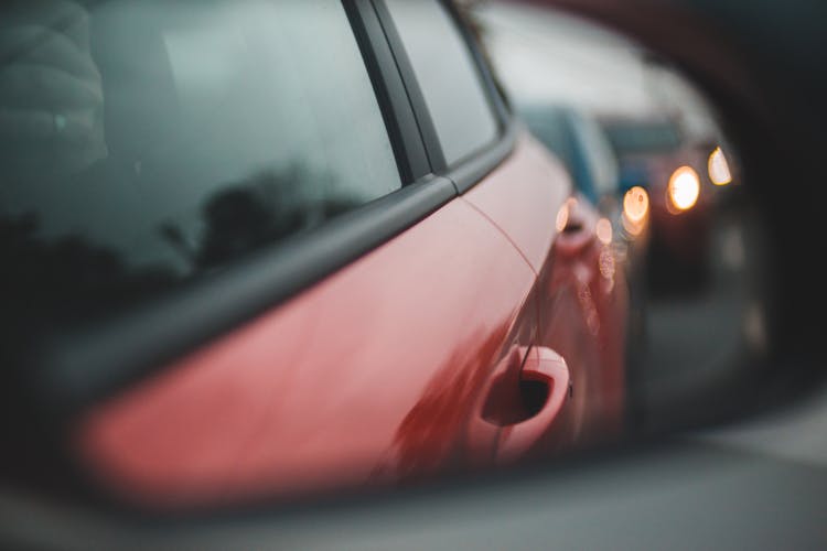 Row Of Modern Cars With Shiny Headlights Reflecting In Mirror