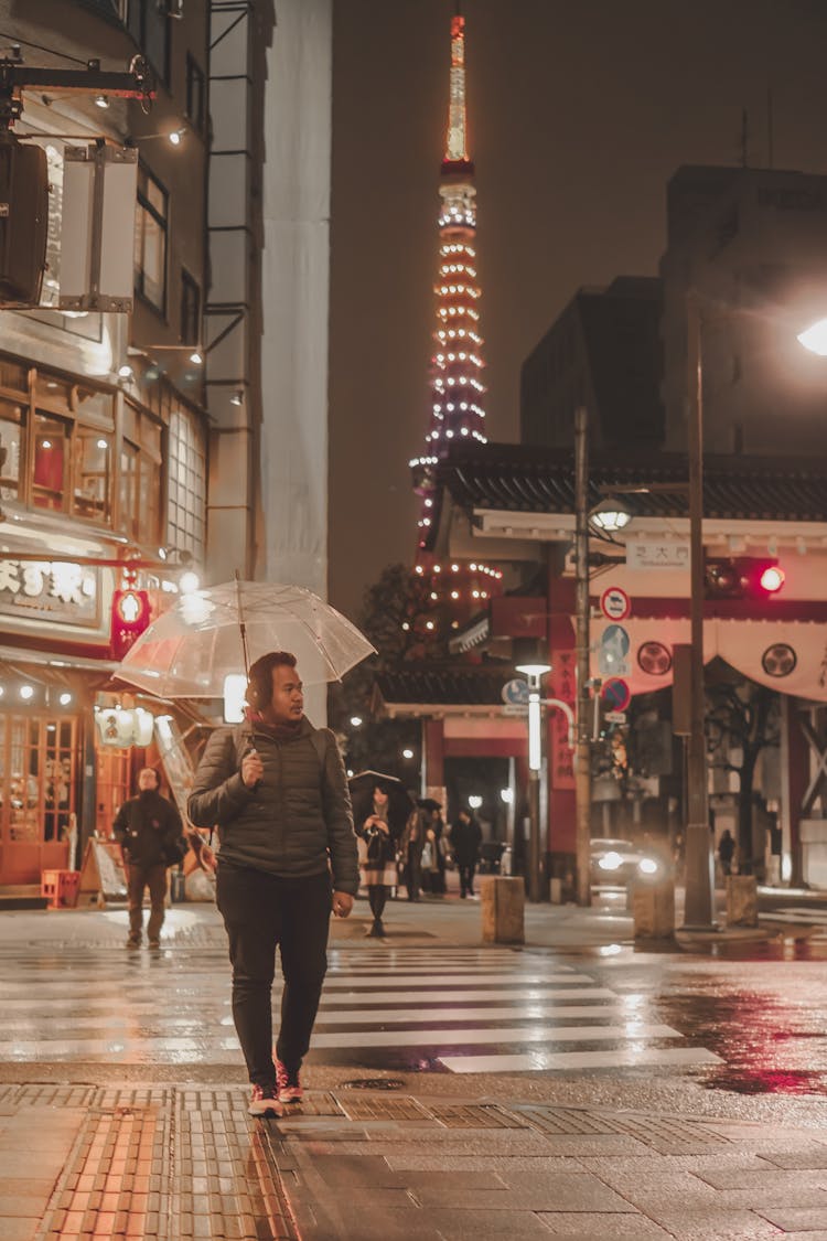 Man Walking On The Sidewalk During Rainy Weather