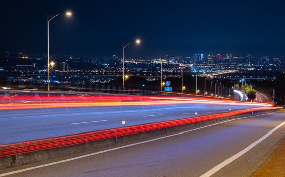 夜晚，充满活力的城市高速公路上，光路与天际线交相辉映