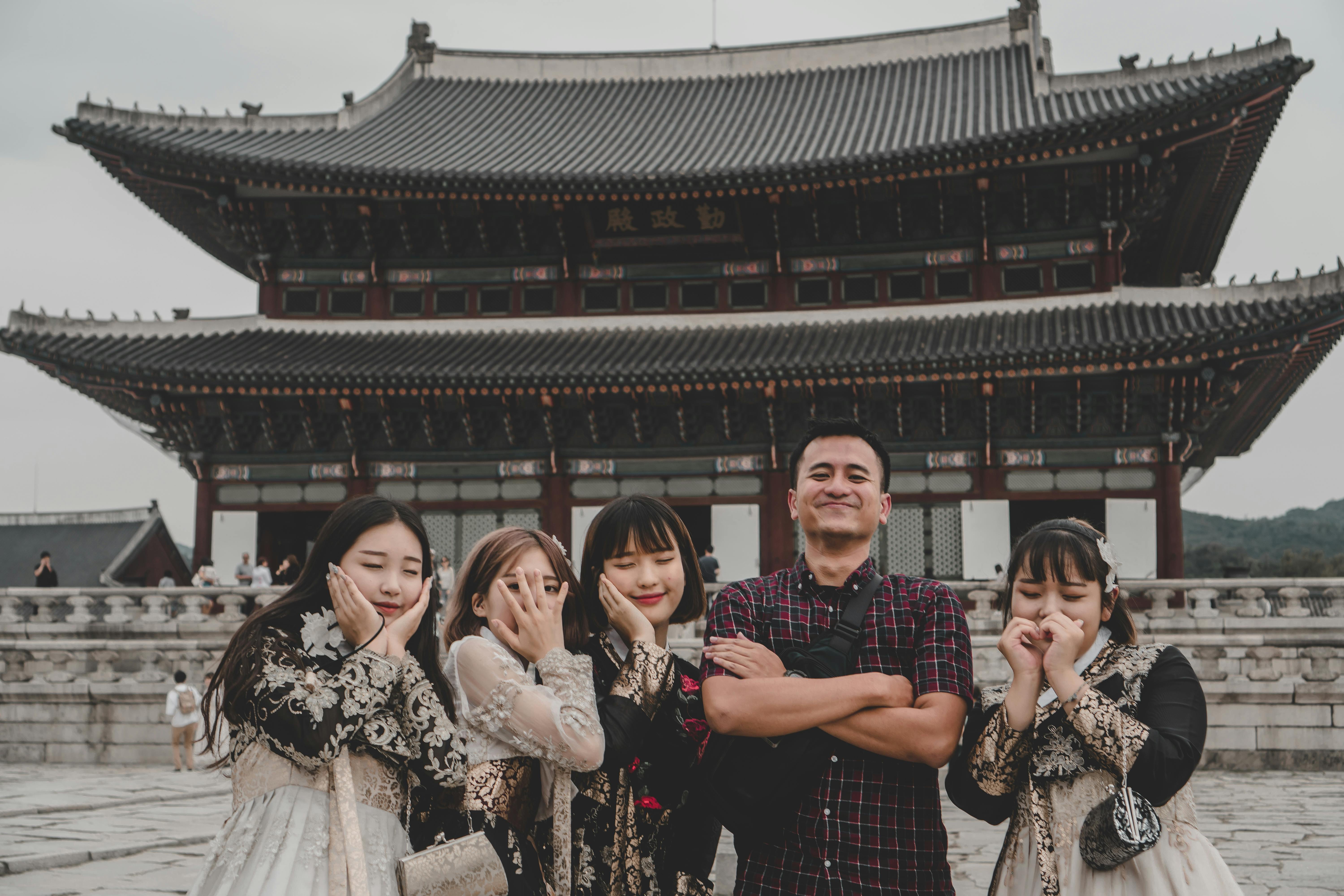 Visitors pose playfully at Gyeongbokgung Palace in Seoul, a famous Korean landmark.