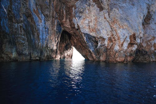 Rough rocky cliff in calm sea