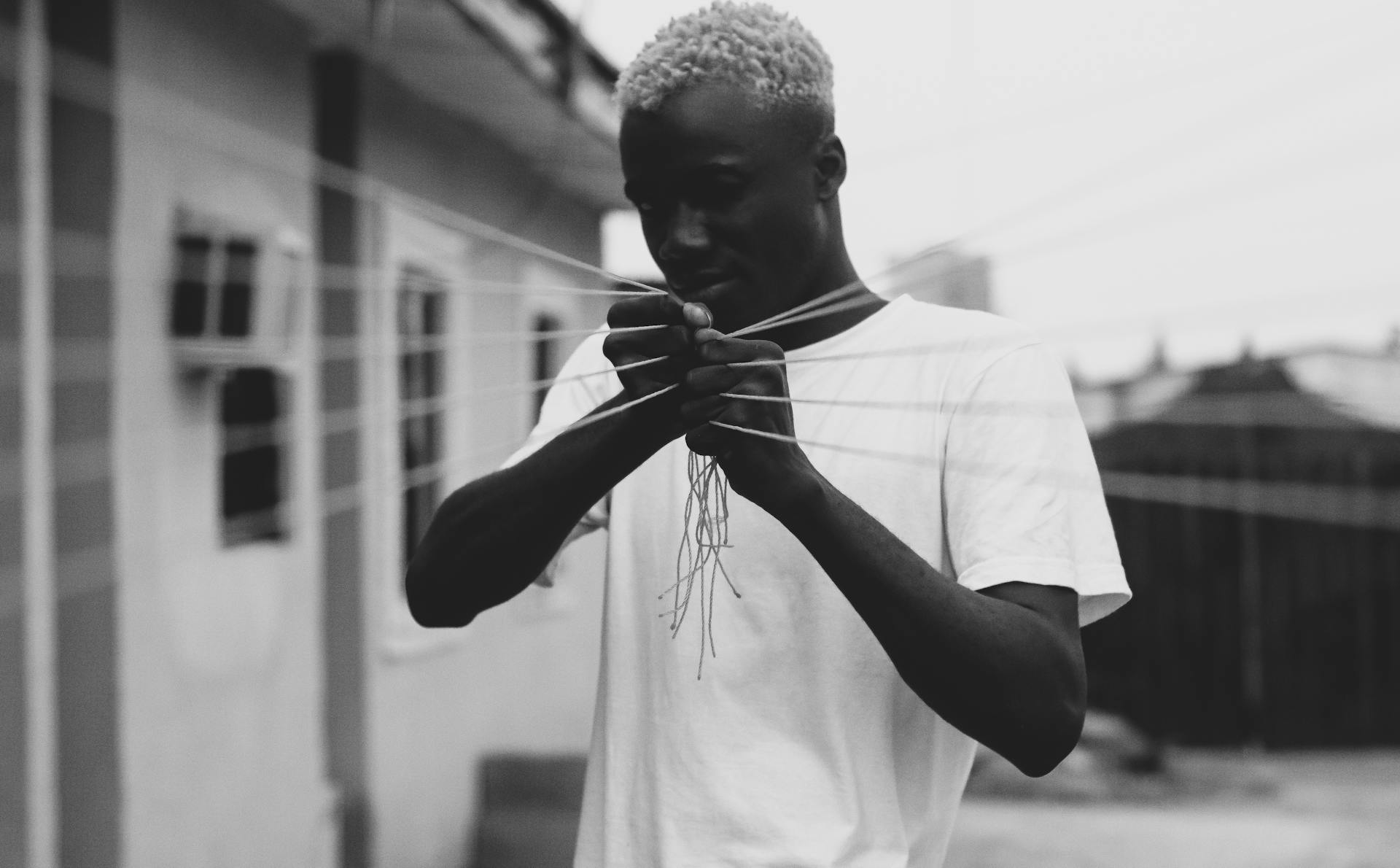 Concentrated young black man pulling elastic threads on street