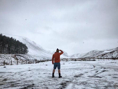 Man Standing on Snow Covered Ground