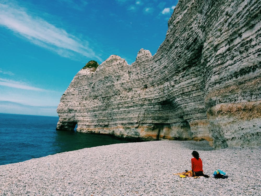 Person Sitting Beside Ocean Water