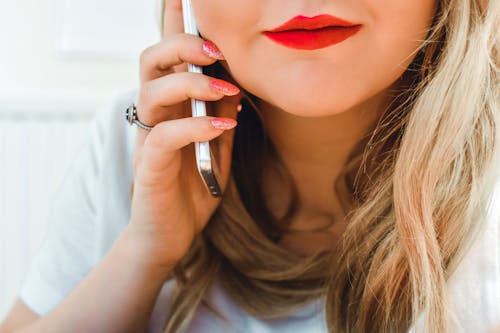 Fotografia Del Primo Piano Della Donna Che Indossa Una Camicia Bianca Che Tiene Il Telefono