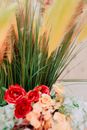 From above soft focus of bunch of roses and tall grass with brown panicles