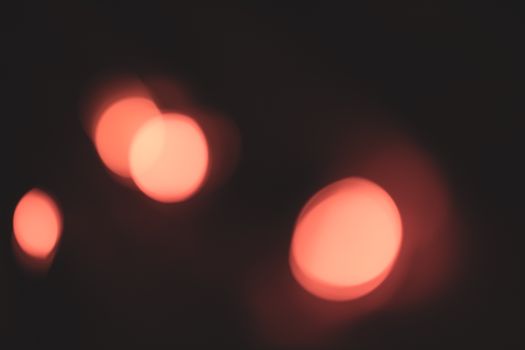 Blurred image capturing abstract warm glowing bokeh circles in soft focus.