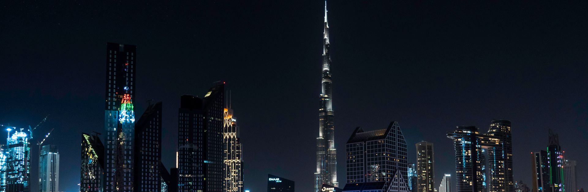 Stunning nighttime view of Dubai's skyline with the iconic Burj Khalifa illuminated under a starry s