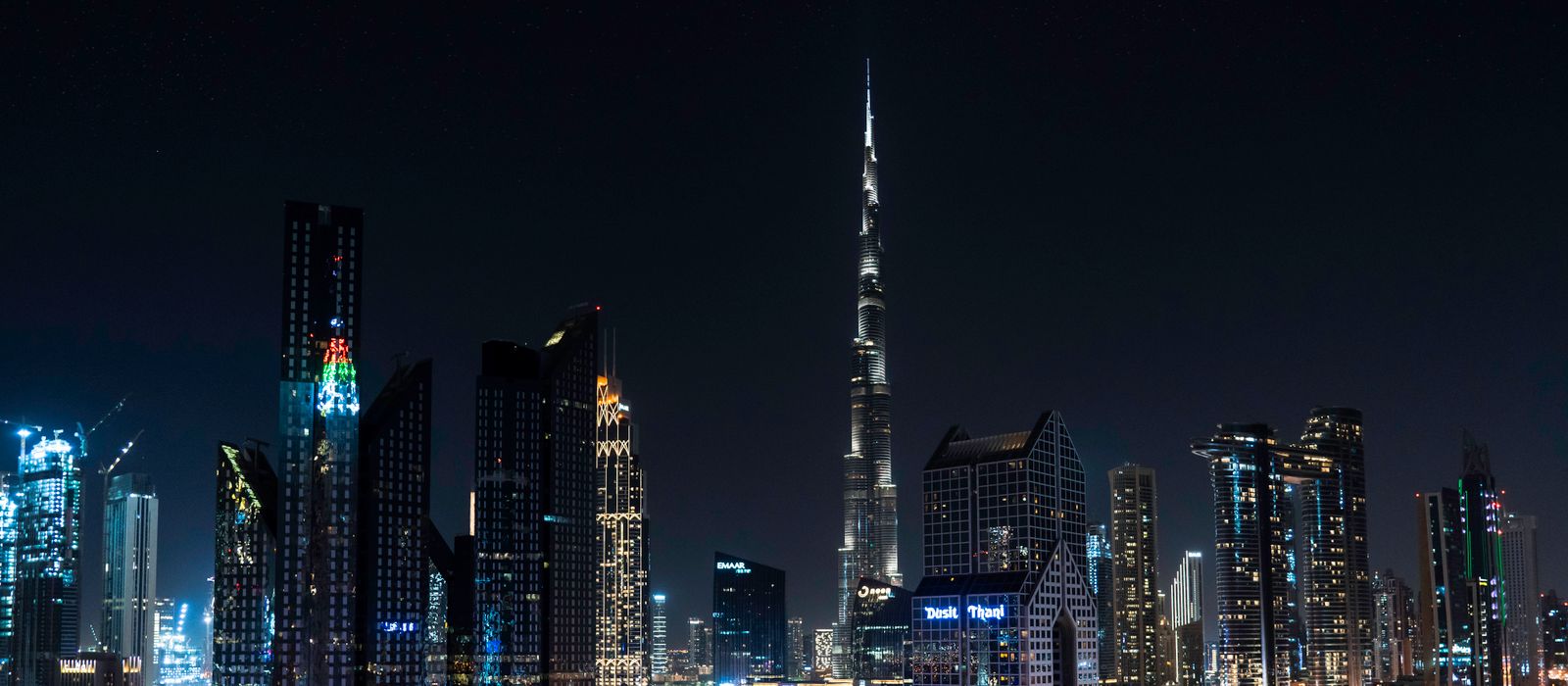 Stunning nighttime view of Dubai's skyline with the iconic Burj Khalifa illuminated under a starry sky.