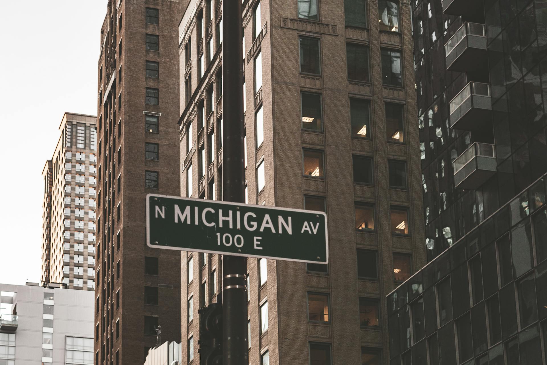 Low angle view of Michigan Avenue sign amidst towering Chicago skyscrapers.