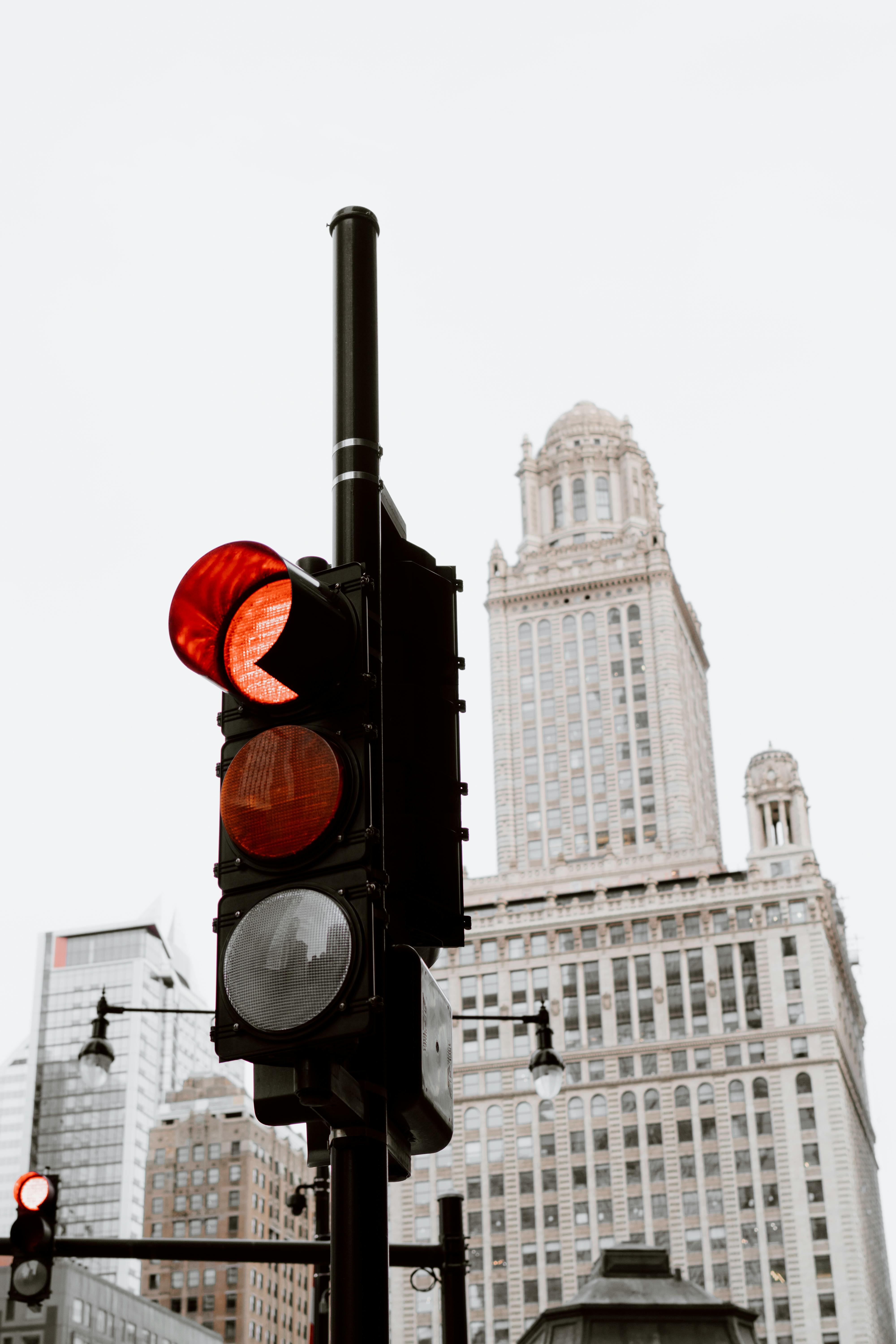 Red traffic light against a historic Chicago skyscraper background, capturing city life.
