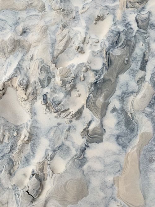 Free Close-up of intricate sand patterns with natural swirls on a beach surface. Stock Photo