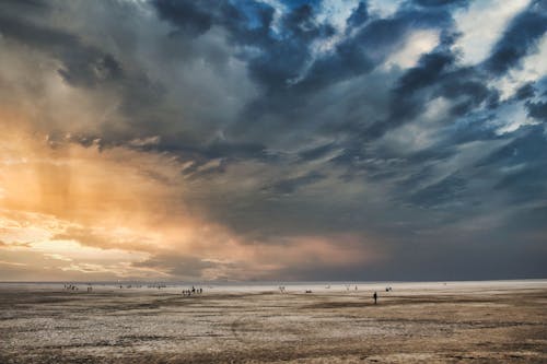 Photo of People Walking on Sand During Dusk