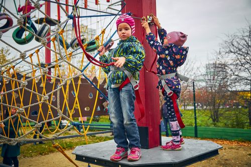 Free Two children enjoying a climbing adventure at an outdoor playground. Fun and safety combined! Stock Photo