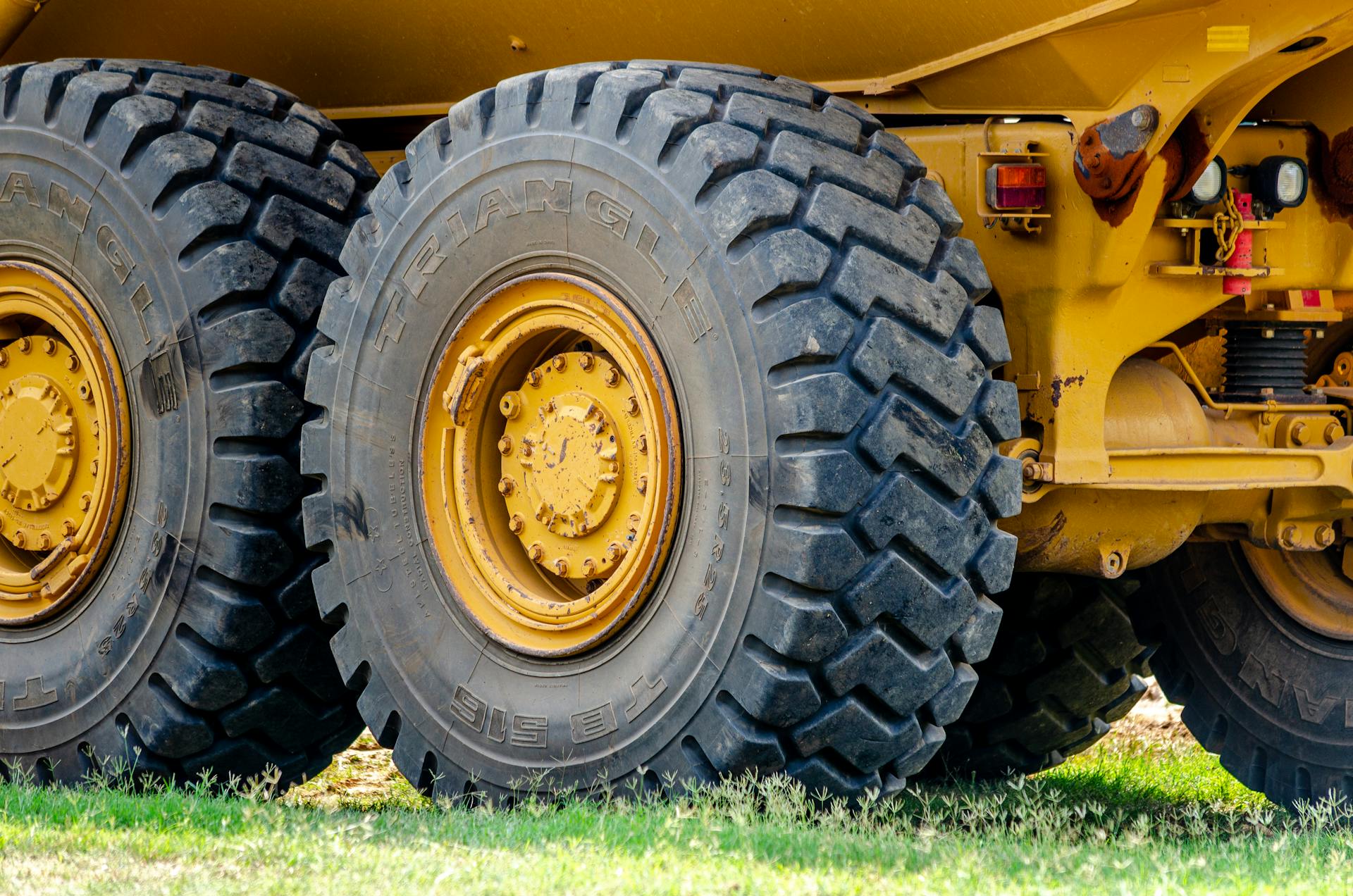 Close-up view of large industrial truck tires in an outdoor setting, showcasing heavy equipment and rugged design.