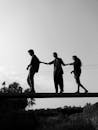 Monochrome Photo of People Crossing A Bridge