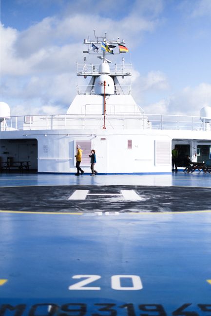 Helipad on a cruise ship with people, showcasing transport and travel lifestyle.