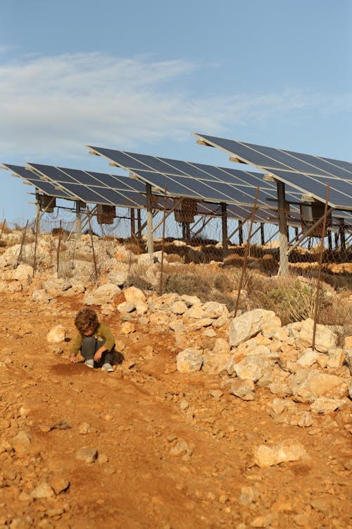 Child on Dirt Road near Solar Panels 