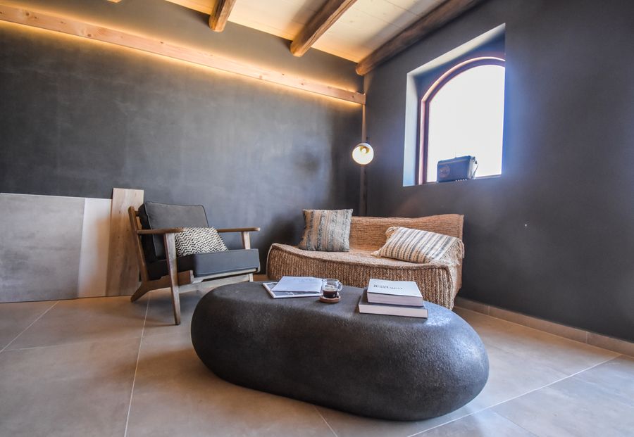Warm office lounge with woven seating and stone table — photo by H O M A D on Pexels