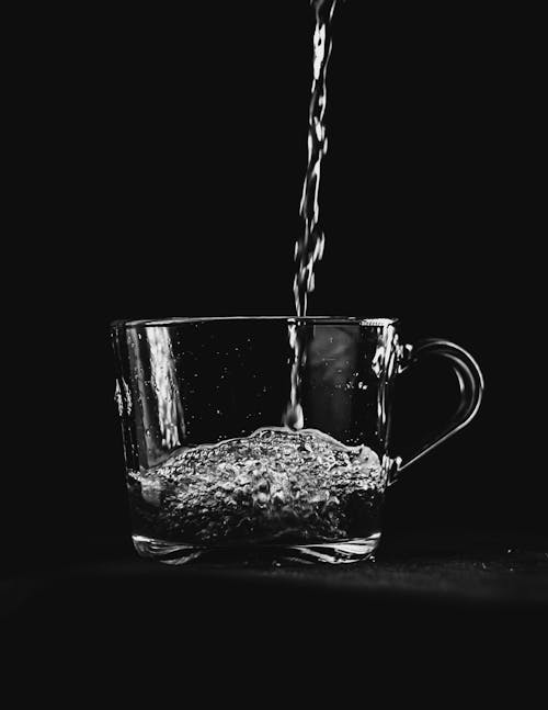 L'eau Coulant Sur Une Tasse En Verre Transparent