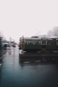 充满活力的长镜头捕捉了一辆历史悠久的电车在多雨的墨尔本穿行，展现了城市交通的活力