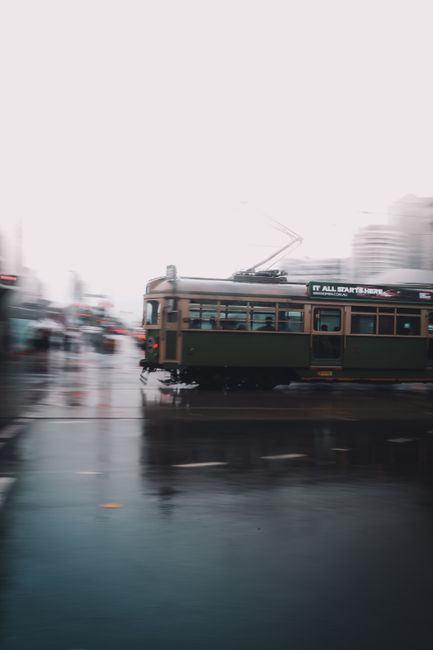 Vibrant long exposure shot of a historic tram in rainy Melbourne, showcasing dynamic urban transport.