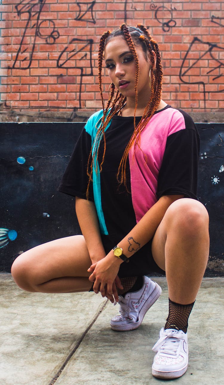 A Woman Crouching On A Concrete Floor