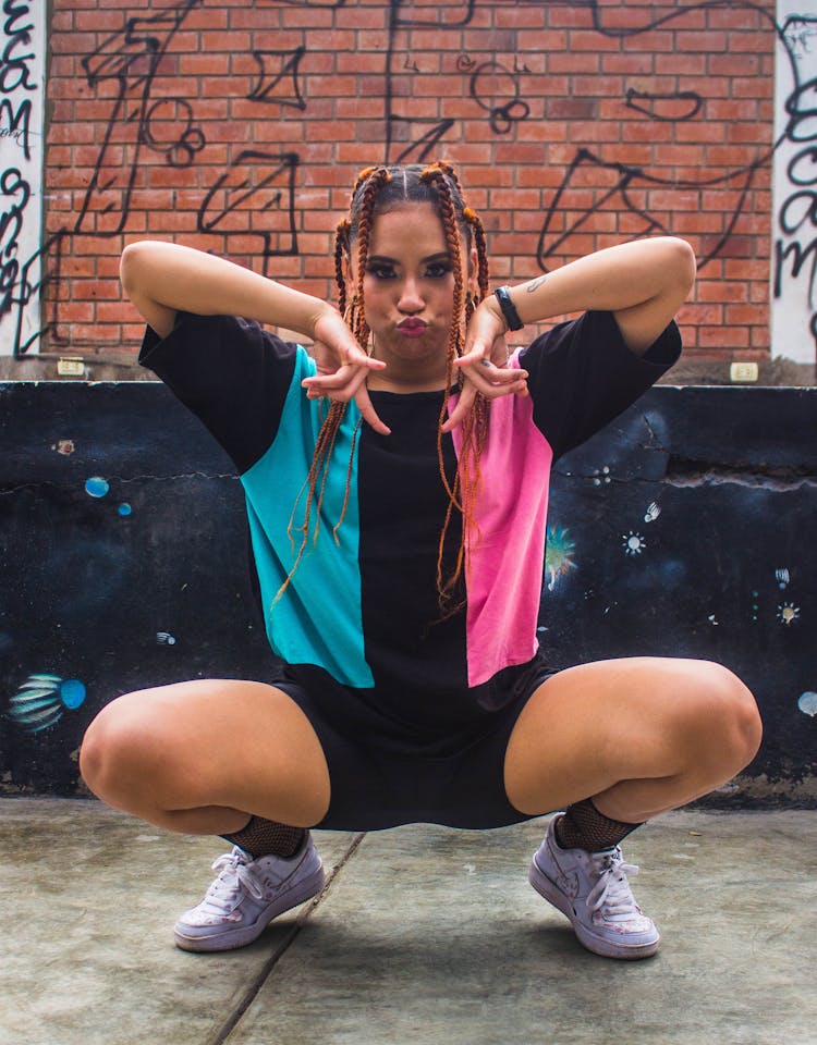 A Woman Pouting While Crouching On The Floor