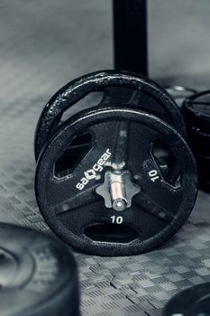 Metal heavy adjustable dumbbell with heavy weigh plates on rubber floor in gym